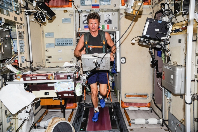 Uzay aracı içinde spor yapan bir astronot.